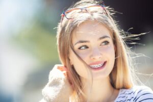 Smiling young woman with braces, showcasing orthodontic treatment benefits, representing Comfort Dental Braces in Federal Way, WA.