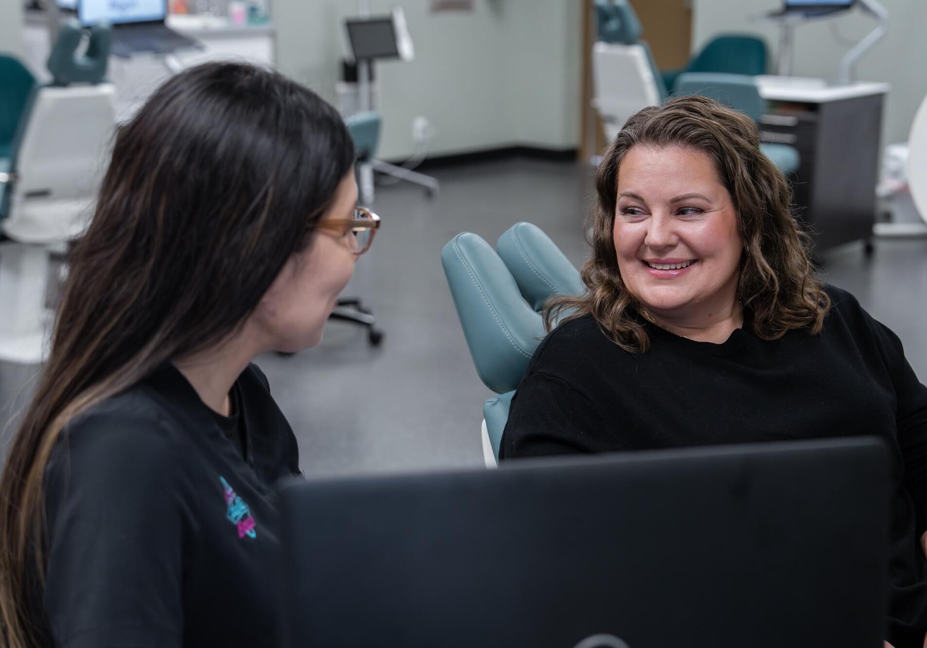 Two women discussing orthodontic treatment in a dental office, highlighting Comfort Dental Braces' personalized care and support for braces in Federal Way, WA.