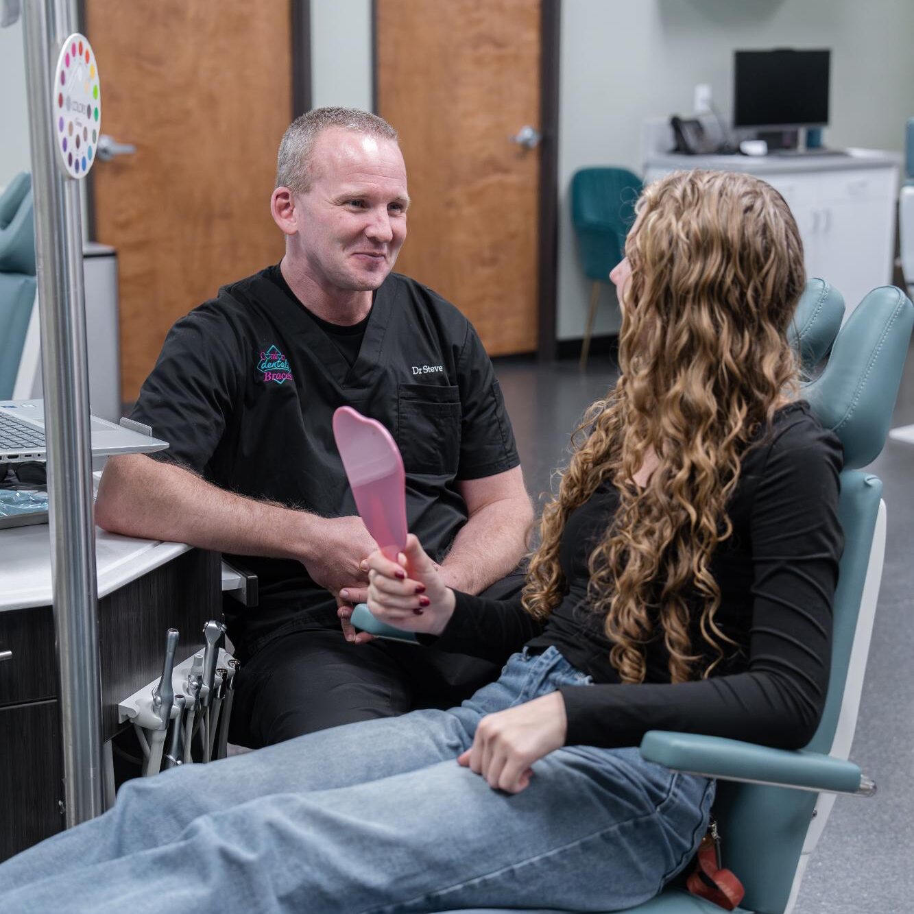 Dr. Steve Clawson engaging with a patient in an orthodontic office, discussing braces options for a confident smile at Comfort Dental Braces in Federal Way, WA.